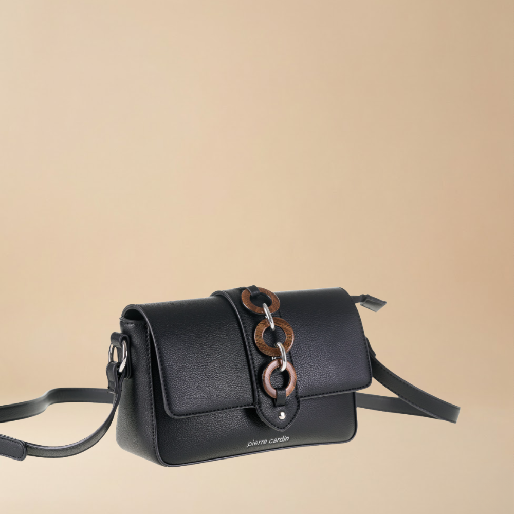 Black handbag with chain detail on a beige background