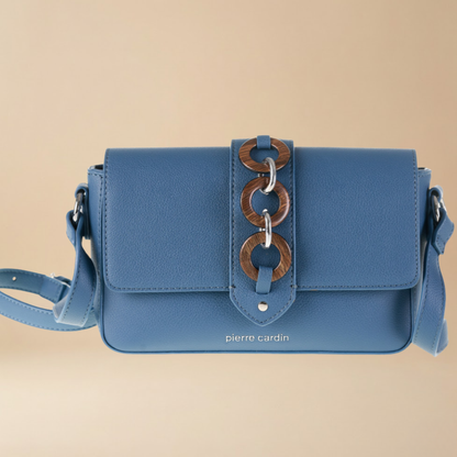 Blue handbag with wooden chain detail on a beige background